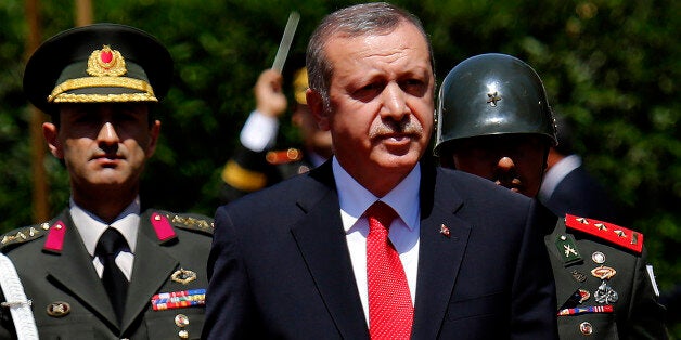 Turkish President Recep Tayyip Erdogan inspects a honor guard during a welcoming ceremony before a meeting with Turkish Cypriot leader Mustafa Akinci in the Turkish-controlled northern part of ethnically divided Cyprus on Monday, July 20, 2015. Erdogan is in Turkish occupied northern Cyprus for a two-day visit to mark the 41th anniversary of the Turkish invasion and occupation of the northern area of the island. Cyprus was split in 1974 when Turkey invaded after a coup by supporters of union with Greece.(AP Photo/Petros Karadjias)