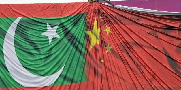 Pakistani labourers arrange a welcome billboard featuring the Chinese and Pakistani national flags ahead of the forthcoming visit by Chinese President Xi Jinping in Islamabad on April 18, 2015. Pakistan needs a 'huge amount of financing' for infrastructure and energy projects and China is ready to announce help when President Xi Jinping visits next week, a foreign ministry official said April 17, 2015. AFP PHOTO / Farooq NAEEM (Photo credit should read FAROOQ NAEEM/AFP/Getty Images)