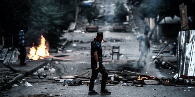 A left-wing protester waits in front of a barricade during clashes with Turkish riot police in the district of Gazi in Istanb