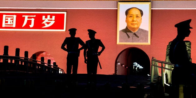 BEIJING, CHINA - JUNE 03: Chinese Paramilitary police officers stand guard below a portrait of the late leader Mao Zedong in front of the Forbidden City at Tiananmen Square on June 4, 2014 in Beijing, China. Twenty-five years ago on June 4, 1989 Chinese troops cracked down on pro-democracy protesters and in the clashes that followed scores were killed and injured. (Photo by Kevin Frayer/Getty Images)