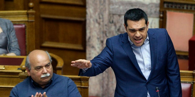 Greek Prime Minister Alexis Tsipras answers opposition questions as Minister of Interior and Administrative Reconstruction Nikos Voutsis applauds him in parliament in Athens, on Friday, July 31, 2015. The third bailout will include a new punishing round of austerity measures heaped on a country reeling from a six-year recession and more than 25 percent unemployment. Tsipras has pledged to back the new cutbacks, while openly admitting that he disagrees with them. (AP Photo/Thanassis Stavrakis)