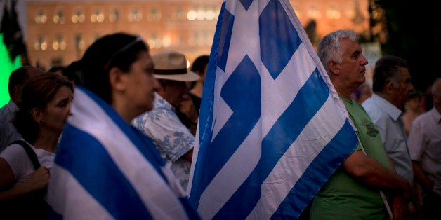 Demonstrators gather near the Greek Parliament during a rally against the government's agreement with its creditors in Athens, in central Athens, Tuesday, July 14, 2015. The eurozone's top official says it's not easy to find a way to get Greece a short-term cash infusion that will help it meet upcoming debt repayments. (AP Photo/Emilio Morenatti)