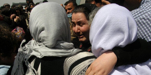 Yazidi women, released by Islamic State group militants, hug as they arrive in Kirkuk, 180 miles (290 kilometers) north of Baghdad, Iraq, Wednesday, April 8, 2015. The Islamic State group released more than 200 Yazidis on Wednesday after holding them for eight months, an Iraqi Kurdish security official said, the latest mass release of captives by the extremists. (AP Photo)