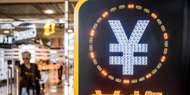 The currency symbol for the Chinese yuan is displayed at a currency exchange store in Hong Kong, China, on Wednesday, Aug. 12, 2015. The yuan sank for a second day, spurring China's central bank to intervene as the biggest rout since 1994 tested the government's resolve to give market forces more sway in determining the exchange rate. Photographer: Xaume Olleros/Bloomberg via Getty Images