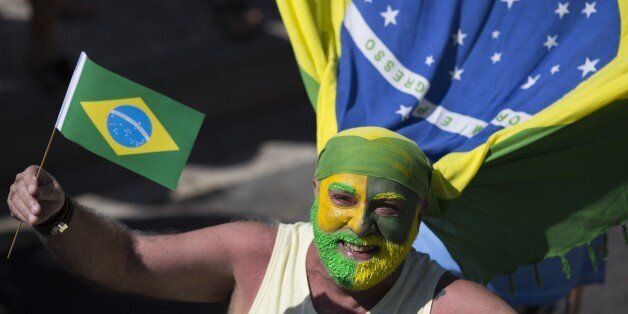 A man poses for the photo with his face painted with the colors of the Brazilian flag during a protest demanding the impeachment of Brazil's President Dilma Rousseff in Rio de Janeiro, Brazil, Sunday, Aug. 16, 2015. Demonstrators are taking to the streets across Brazil for a day of nationwide anti-government protests. President Rousseff's second term in office has been shaken by a snowballing corruption scandal involving politicians from her Workersâ Party, as well as a spluttering economy, spiraling currency and rising inflation, making her popularity ratings fall to historic lows. (AP Photo/Leo Correa)