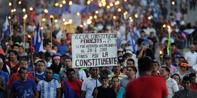 Demonstrators demanding the resignation of President Juan Orlando Hernandez over an ongoing corruption scandal demonstrate in Tegucigalpa on August 21, 2015. The demonstrators, known as 'indignados' -- the indignant ones -- hit the streets bearing torches as every Friday in the past weeks demanding the creation of an anti-corruption commission and calling for Hernandez to go while rejecting any dialogue with him AFP PHOTO/Orlando SIERRA (Photo credit should read ORLANDO SIERRA/AFP/Getty Images)