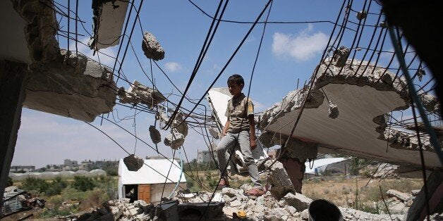 A Palestinian boy plays in the rubble of houses destroyed during the 50-day war between Israel and Hamas militants in the sum