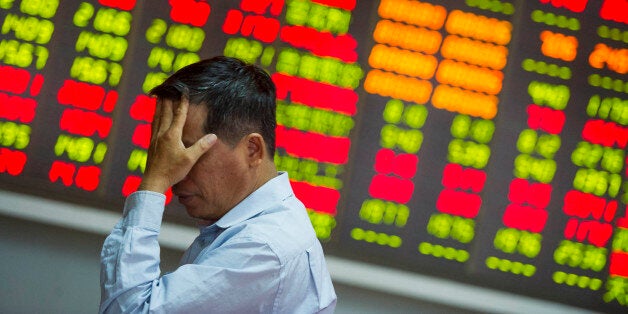 HAIKOU, CHINA - AUGUST 26: (CHINA OUT) An investor reacts at a stock exchange hall on August 26, 2015 in Haikou, China. Chinese shares plunged on Wednesday with the benchmark Shanghai Composite Index down 37.68 points, or 1.27 percent, to close at 2,927.29. The Shenzhen Component Index fell 298.22 points, or 2.92 percent, to close at 9,899.72. (Photo by Luo Yunfei/CNSPHOTO/ChinaFotoPress/ChinaFotoPress via Getty Images)