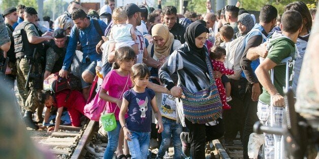 Macedonian police allow migrants to cross in Macedonia on a border line between Greece and Macedonia near the town of Gevgelija on August 25, 2015. More than 1,500 mostly Syrian refugees, trapped in a no-man's land for three days, entered Macedonia from Greece, after police allowed them to pass despite earlier trying to hold back the crowd using stun grenades. Migrants who crossed the Macedonia-Greece border are now streaming into European Union member state Hungary, with a record 2,093 crossing over from Serbia on August 24, 2015. AFP PHOTO / ROBERT ATANASOVSKI (Photo credit should read ROBERT ATANASOVSKI/AFP/Getty Images)