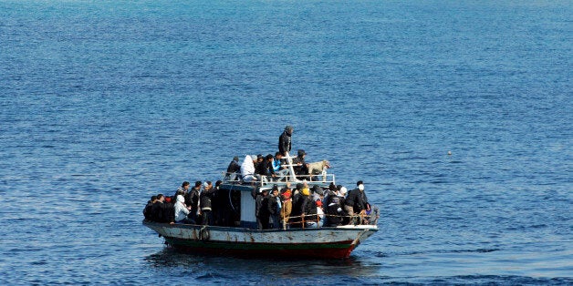 A boatload of would-be migrants believed to be from North Africa is seen moments before being rescued by the Italian Coast Gu
