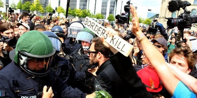 BERLIN, GERMANY - JUNE 21: Protesters gather with German riot police in front of the German Parliament Building on June 21, 2015 in Berlin, Germany. A German artist group called 'Political Beauty' ('Politische Schoenheit') organized the event as a form of protest against European Union refugee policy. (Photo by Mehmet Kaman/Anadolu Agency/Getty Images)