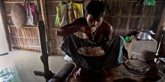 A boy eats rice inside his house partially submerged in flood waters at Gagolmari village 85 kilometers (53 miles) east of Gauhati, India, Wednesday, Sept. 2, 2015. Monsoon floods have inundated hundreds of villages across the northeast Indian state of Assam, killing at several people and forcing some 800,000 people to leave their homes. (AP Photo/Anupam Nath)