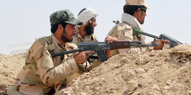 Iraqi Shiite fighters from the Popular Mobilisation units monitor the frontline during clashes with the Islamic State (IS) group in the town of Saqlawiya on the outskirts of Fallujah, 50kms west of Baghdad, on July 26, 2015. Iraqi government forces gained control over Al-Anbar University from Islamic State (IS) Group, near Ramadi, a key position to reclaim the provincial capital, according to officials. AFP PHOTO/ AHMAD AL-RUBAYE (Photo credit should read AHMAD AL-RUBAYE/AFP/Getty Images)