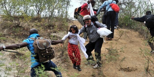 Migrants and refugees cross from Greece into Macedonian near the village of Idomeni, in northern Greece on September 8, 2015.
