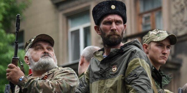 Pro-Russia rebels stand guard during funeral of prominent separatist commander Alexei Mozgovoi in Alchevsk, Ukraine, Wednesday, May 27, 2015. Alexei Mozgovoi and at least six other people were killed on Saturday in eastern Ukraine when his vehicle was ripped apart by a bomb and then strafed by gunfire. (AP Photo/Mstyslav Chernov)