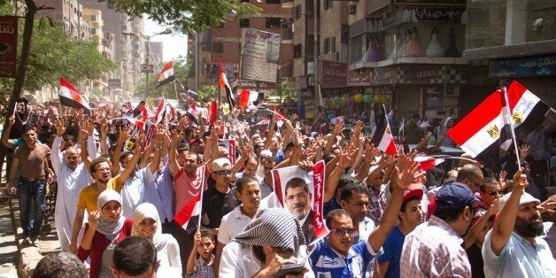 Members of the Muslim Brotherhood hold up pictures of their ousted President Mohammed Morsi during a protest two years after