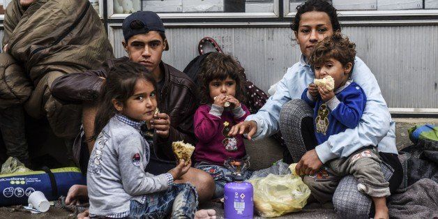 Migrants and refugees eat breakfast near a registration camp in the southern Serbian town of Presevo on September 11, 2015. A record 5,000 migrants have arrived at Serbia's border with Hungary over the past 24 hours, a television report said on September 10. Some 3,000 of them have already entered into Hungary, the state RTS television said. Most of the migrants are moving through Hungary on their way to Germany and other northern countries where they hope to win asylum. Some 50 buses transporting around 2,500 migrants as well as three trains with around 3,000 others left on September 9 to 10 overnight from Gevgelija, on the Macedonian side of its border with Greece towards Serbia, according to AFP journalists. The EU unveiled plans to take 160,000 refugees from overstretched border states, as the United States said it would accept more Syrians to ease the pressure from the worst migration crisis since World War II. AFP PHOTO / ARMEND NIMANI (Photo credit should read ARMEND NIMANI/AFP/Getty Images)