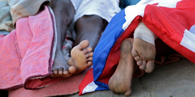 Migrants sleep on the rocky beach at the Franco-Italian border near Menton, southeastern France Wednesday, June 17, 2015. European Union nations failed to bridge differences Tuesday over an emergency plan to share the burden of the thousands of refugees crossing the Mediterranean Sea, while on the French-Italian border, police in riot gear forcibly removed dozens of migrants. (AP Photo/Lionel Cironneau)