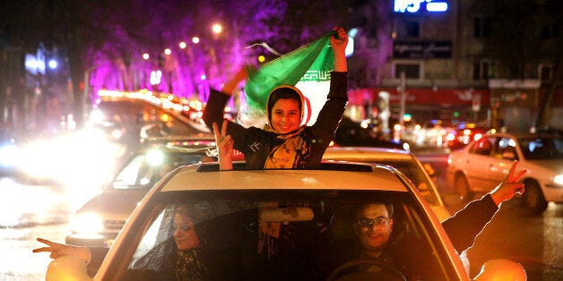 Iranians celebrate on a street in northern Tehran, Iran, Thursday, April 2, 2015, after Iran's nuclear agreement with world powers in Lausanne, Switzerland. Iran and six world powers reached a preliminary nuclear agreement Thursday outlining commitments by both sides as they work for a comprehensive deal aiming at curbing nuclear activities Tehran could use to make weapons and providing sanctions relief for Iran. (AP Photo/Ebrahim Noroozi)