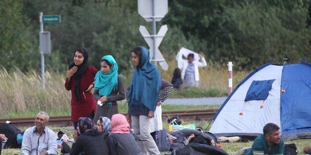 HEILIGENKREUZ, AUSTRIA - SEPTEMBER 14: Refugees are seen on the border camp as they wait for bus transfer to Graz, Austria on September 14, 2015 after they crossed Hungary, Austria border. (Photo by Ales Beno/Anadolu Agency/Getty Images)