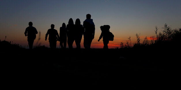 People arrive at a temporary holding center for migrants in the early morning near the border between Serbia and Hungary in R