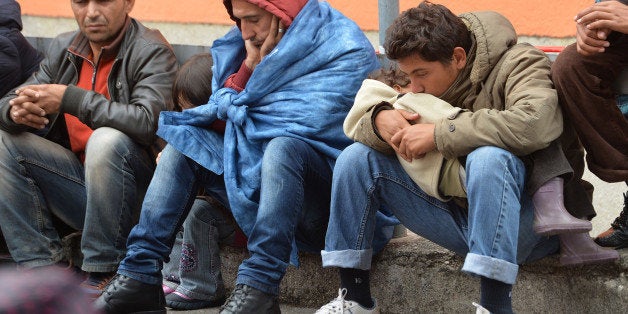 Migrants sit on a platform at the rail station in Freilassing, Germany, Monday, Sept. 14, 2015, after they have been taken of