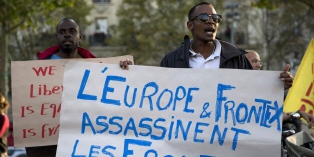 People shout slogans and hold placard reading 'Europe and Frontex assassinate, the borders kill' as part of a demonstration in support of migrants at the Place de la Republique in Paris on September 8, 2015. As European Union leaders stepped up efforts to tackle the region's largest migrant crisis since World War II, France said it would take 24,000 more asylum-seekers under a plan to relocate 120,000 refugees from hard-hit frontline countries. AFP PHOTO / KENZO TRIBOUILLARD (Photo credit should read KENZO TRIBOUILLARD/AFP/Getty Images)