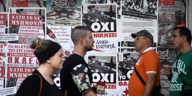 Pedestrians pass posters of left-wing parties in the northern Greek city of Thessaloniki, Tuesday, Sept. 15, 2015. Alexis Ts
