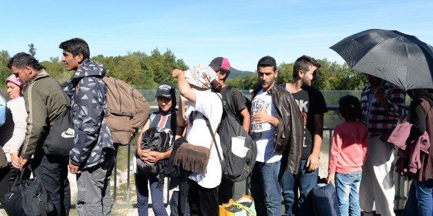 Refugees wait for police controls on a bridge crossing the border between Austria and Germany after leaving on foot Salzburg on their way to the Bavarian village of Freilassing, southern Germany, on September 16, 2015. Germany took the drastic measure of reinstating border controls on September 13, 2015 after being overwhelmed by a surge in asylum-seekers.AFP PHOTO / CHRISTOF STACHE (Photo credit should read CHRISTOF STACHE/AFP/Getty Images)