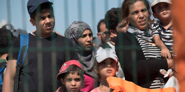 Syrian migrants who were rescued by Turkish Coast Guard while trying to cross in boats to Greece, walk towards a bus to be ta