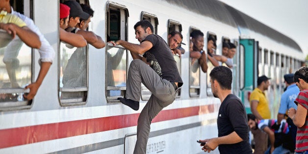 BELI MANASTIR, CROATIA - SEPTEMBER 18: Migrants climb through windows to board trains at the train station in Beli Manastir, near Hungarian border on September 18, 2015 in Beli Manastir,Croatia. Officials are saying that they had no choice than to close eight road border crossings yesterday after more than 11,000 people entered the country since Hungary fenced off its border with Serbia earlier this week. (Photo by Jeff J Mitchell/Getty Images)