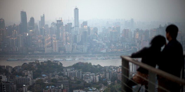 In this Tuesday April 3, 2012 photo, a couple observe the city skyline at a viewpoint in southwestern China's Chongqing city. (AP Photo/Alexander F. Yuan)