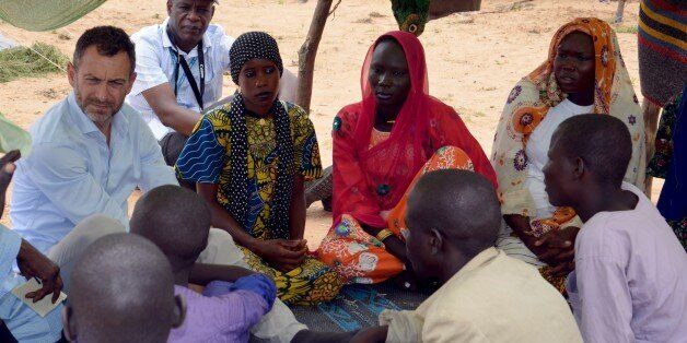 A picture taken on September 16, 2015 shows Toby Lanzer, United Nations humanitary regional coordinator for the Sahel,speaking to refugees living in the Assaga refugee camp, in the Diffa region, set up by the United Nations three months ago for Nigerian refugees who fled to southeast Niger to escape the Islamist militant militia Boko Haram. Thousands of Nigerian refugees who fled to southeast Niger to escape the Islamist group Boko Haram are in an 'atrocious' situation, the United Nations says. In six years of bloodshed, the Boko Haram insurgency to carve out an Islamic state in northeast Nigeria has left at least 15,000 dead and left more than two million others homeless. AFP PHOTO / BOUREIMA HAMA (Photo credit should read BOUREIMA HAMA/AFP/Getty Images)