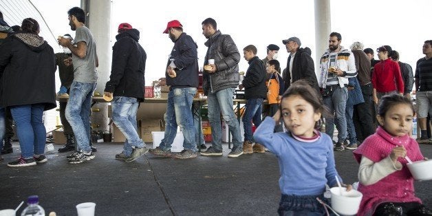 HEGYESHALOM, HUNGARY - SEPTEMBER 23 : Hundreds of refugees receive food as they arrive at the Hungarian and Austrian border in Hegyeshalom, Hungary on September 23, 2015. (Photo by Arpad Kurucz/Anadolu Agency/Getty Images)