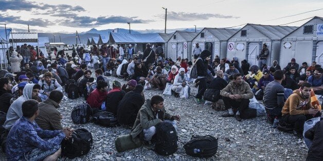 Migrants and refugees wait to board a train near Gevgelija in southern Macedonia after crossing the Greek-Macedonian border on September 27, 2015. Macedonia is a key transit country in the Balkans migration route into the EU, with thousands of asylum seekers and migrants - many of them from Syria, Afghanistan, Iraq and Somalia - entering the country every day. AFP PHOTO / ARMEND NIMANI (Photo credit should read ARMEND NIMANI/AFP/Getty Images)