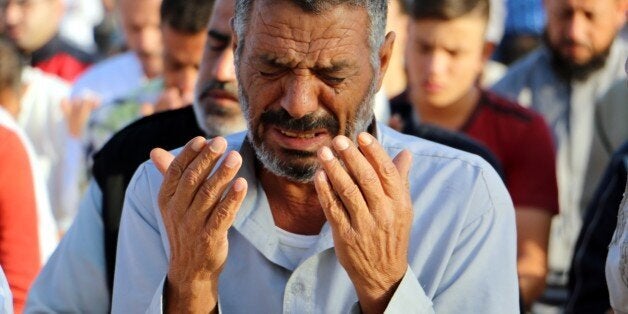 SANLIURFA, TURKEY - SEPTEMBER 24: Syrian refugees holding on life in the Suleyman Sah accommodation for refugees in Akcakale district in Sanliurfa perform prayer during the Eid al-Adha celebrations on September 24, 2015. Muslims around the world celebrate the Eid al-Adha, also called the Feast of the Sacrifice, to commemorate Prophet Abraham's readiness to sacrifice his son as an act of obedience to God. (Photo by Muslum Etgu/Anadolu Agency/Getty Images)