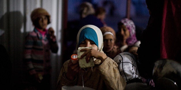 FILE - In this file photo taken Sunday, Dec. 9, 2012, Syrian girls wait for food distribution at a refugee camp near the Turk