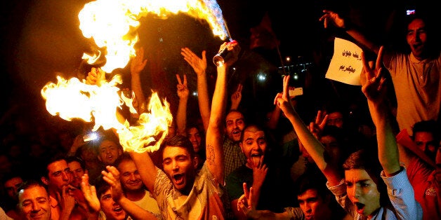 Iranians celebrate following a landmark nuclear deal in Tehran, Iran, Tuesday, July 14, 2015. Overcoming decades of hostility, Iran, the United States, and five other world powers struck a historic accord Tuesday to check Tehran's nuclear efforts short of building a bomb. The agreement could give Iran access to billions in frozen assets and oil revenue, stave off more U.S. military action in the Middle East and reshape the tumultuous region. (AP Photo/Ebrahim Noroozi)