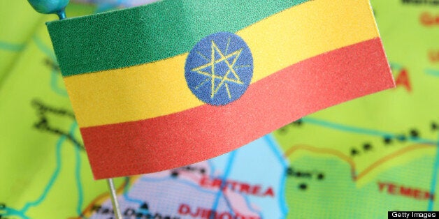 Ethiopian flag over cheap plastic map pointing Addis Abeba. Shallow depth of field