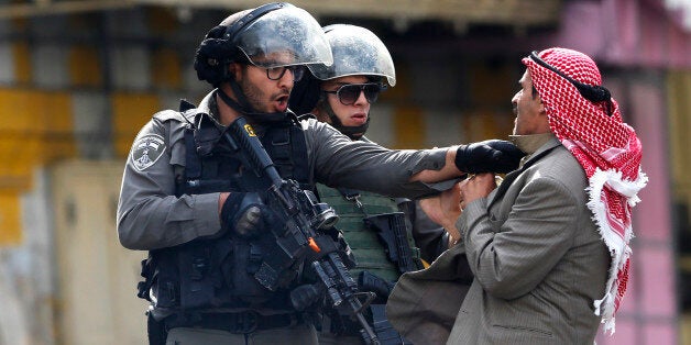 A Palestinian is pushed an Israeli policemen amid clashes in Hebron, West Bank, Saturday, Oct. 10, 2015. A Palestinian teenager stabbed two Israelis in Jerusalem Saturday before being shot dead by police forces, the latest in a series of stabbing attacks against civilians and soldiers that have spread across Israel and the West Bank in the past week. The violence, including the first apparent revenge attack by an Israeli Friday and increasing protests by Israel's own Arab minority, has raised fears of the unrest spiraling further out of control. (AP Photo/Nasser Shiyoukhi)