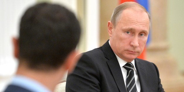 Russian President Vladimir Putin (R) listens to his Syrian counterpart Bashar al-Assad during a meeting at the Kremlin in Moscow on October 20, 2015. Assad, on his first foreign visit since Syria's war broke out, told his main backer and counterpart Putin in Moscow that Russia's campaign in Syria has helped contain 'terrorism'. AFP PHOTO / RIA NOVOSTI / KREMLIN POOL / ALEXEY DRUZHININ (Photo credit should read ALEXEY DRUZHININ/AFP/Getty Images)