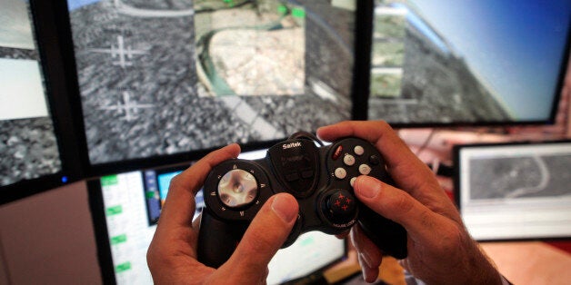 With a view on the screens of downtown Baghdad, Iraq, Mark Bigham, director of business development for US Raytheon Tactical Intelligence Systems, uses a Playstation-style console to maneouvre the 'aircraft', as he shows the company's newly-unveiled control system for unmanned drones, at the Farnborough aerospace show, in Farnborough, England, Thursday July 17, 2008. There is rapidly growing use of umanned aerial vehicles, or UAVs, in both military operations and civil environments around the world. The war on terror has spurred the use of drones in combat areas, with unmanned aircraft currently flown by the U.S. Air Force and the British Royal Air Force in both Iraq and Afghanistan. (AP Photo/Lefteris Pitarakis)