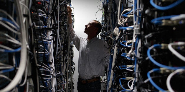 FILE PHOTO: An employee checks cabling on data storage devices in the computer data center at the head office of Alcatel-Luce