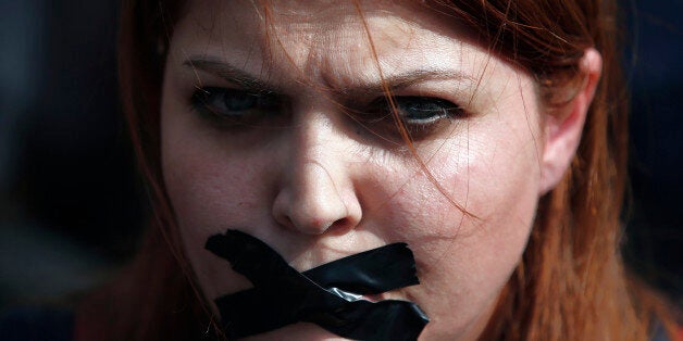 A woman places a bandage other mouth as she protests Saturday's explosions in Ankara, Turkey, Tuesday, Oct. 13, 2015. Authorities in Istanbul banned a protest rally and march by the same trade union and civic society groups who lost friends and colleagues in Turkey's bloodiest terror attack. Dogan news agency video footage on Tuesday showed police pushing back dozens of demonstrators trying to reach the rally to commemorate the 97 victims of the twin suicide bombings. Some demonstrators were detained.(AP Photo/Emrah Gurel)