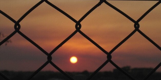 Picture of a sunset behind bars