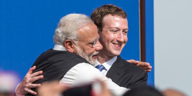 Narendra Modi, India's prime minister, left, and Mark Zuckerberg, chief executive officer of Facebook Inc., embrace at the conclusion of a town hall meeting at Facebook headquarters in Menlo Park, California, U.S., on Sunday, Sept. 27, 2015. Prime Minister Modi plans on connecting 600,000 villages across India using fiber optic cable as part of his 'dream' to expand the world's largest democracy's economy to $20 trillion. Photographer: David Paul Morris/Bloomberg via Getty Images 