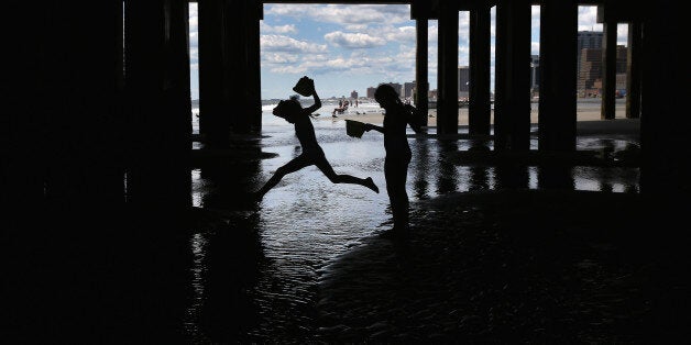 ATLANTIC CITY, NJ - AUGUST 28: Children play under a pier near the closed Trump Plaza hotel on August 28, 2015 in Atlantic C