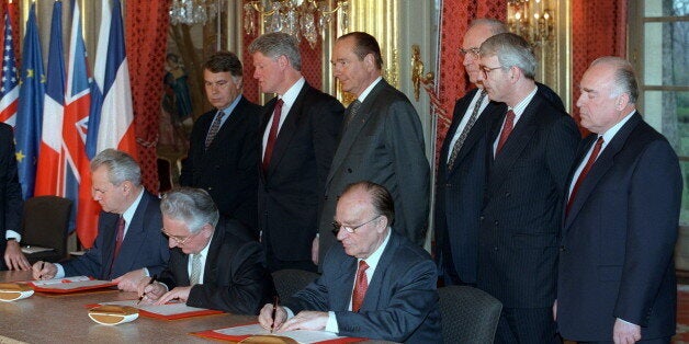 From left background : Spanish Prime Minister Felipe Gonzalez, US President Bill Clinton, French President Jacques Chirac, German Chancellor Helmut Kohl, British Prime Minister John Major and Russian Premier Victor Chernomyrdin, from left front Serbian President Slobodan Milosevic, Croatian President Franjo Tudjman and Bosnian President Alija Izetbegovic sign the peace agreement on Bosnia at the ElysÃ©e Palace in Paris 14 December 1995. The accord was reached in Dayton, USA, 21 November ending over four years of war in former Yugoslavia. (Photo credit should read MICHEL GANGNE/AFP/Getty Images)