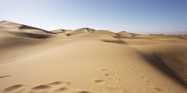 Sahara desert close to Merzouga in Morocco with blue sky and clouds.