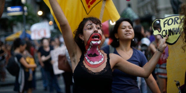 Women shout slogans against possible changes in abortion laws as Congress debates a new abortion bill in Rio de Janeiro, Brazil, Wednesday, Oct. 28, 2015. The proposed bill would make it a crime to induce or assist a pregnant woman with an abortion. Currently, only women who were raped, whose life is in danger, or whose fetus is gravely deformed can legally have an abortion. The new law, if passed, would require a rape victim to get a forensic exam and file a police report to prove they are the victim of sexual violence. (AP Photo/Silvia Izquierdo)